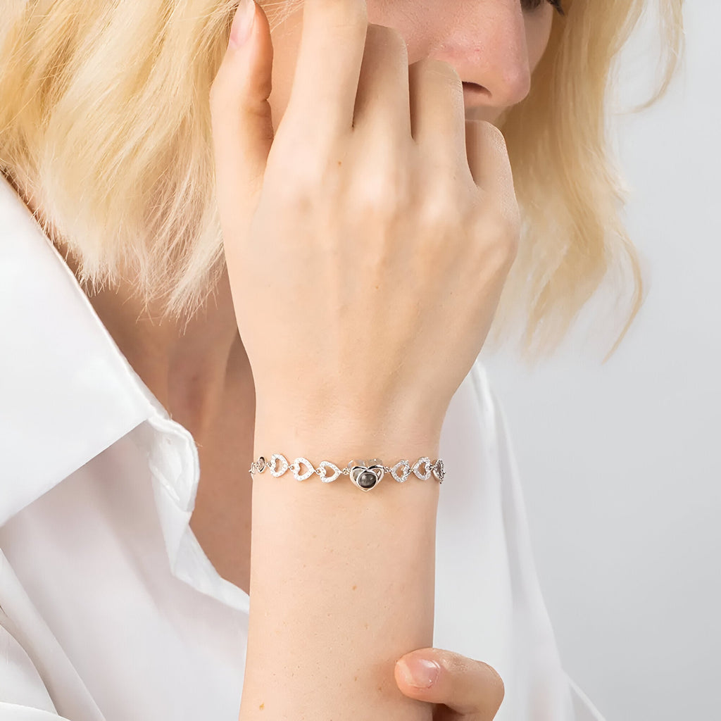 Bracelet en argent sterling avec multiples cœurs perforés et cœur central gravé, style délicat.