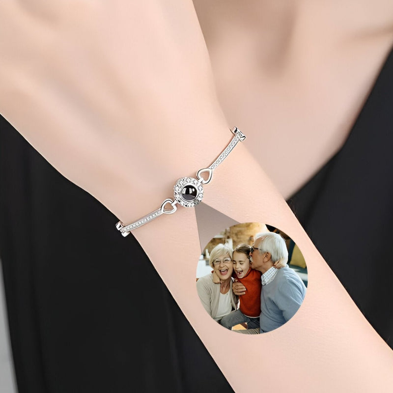 Bracelet fin en argent avec médaillon photo circulaire et zirconium noir sur poignet féminin.