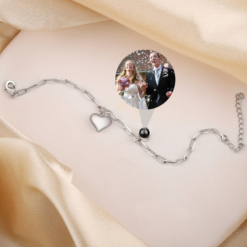 Bracelet photo personnalisé en titane argenté avec charm cœur ajouré et chaîne fine.