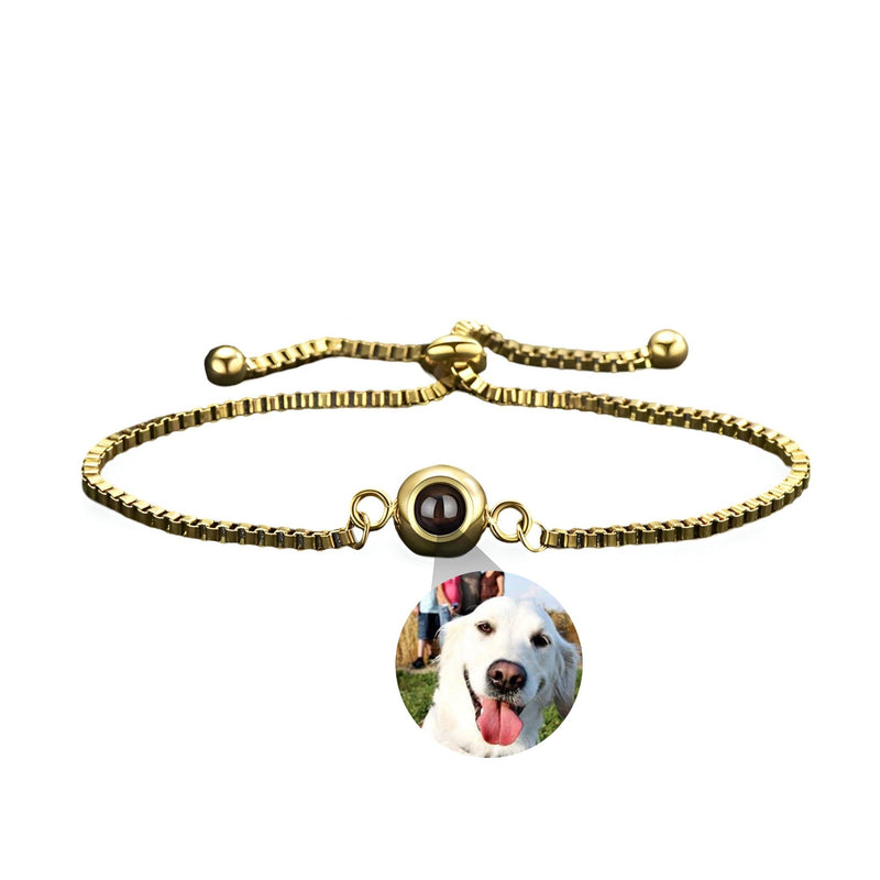 Bracelet photo personnalisé en titane or avec médaille ronde et photo de chien blanc souriant.