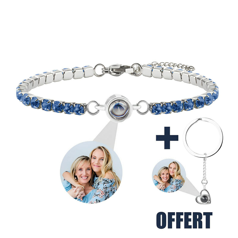 Bracelet en titane argenté avec pierres bleues serties et médaillon photo personnalisé accompagné d’un porte-clé cœur offert.