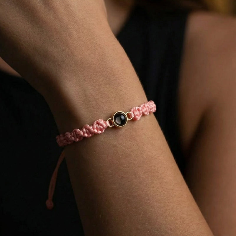 Bracelet tressé en nylon rose avec fermoir coulissant et médaillon photo circulaire noir et or.