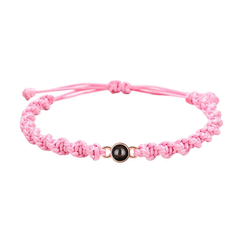Bracelet tressé en nylon rose avec perle noire centrale et fermoir coulissant ajustable.