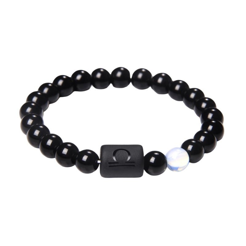 Bracelet noir en perles de verre rondes avec un lien carré gravé du symbole astrologique Balance et une perle blanche irisée