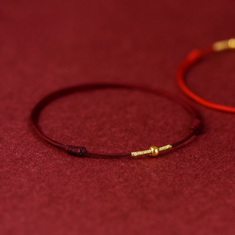 Bracelet en nylon fil rouge bordeaux avec fermoir métal doré fin et élégant.