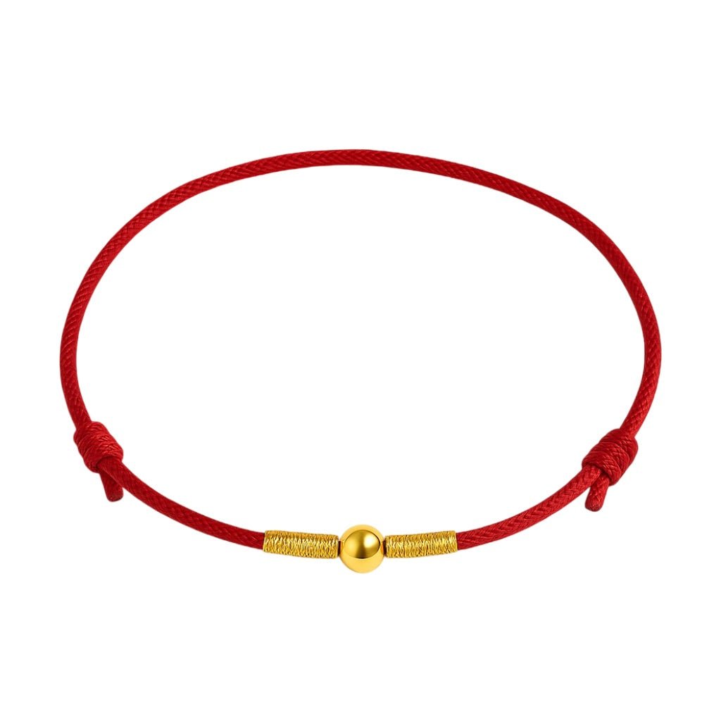 Bracelet porte-bonheur en fil rouge nylon avec perle dorée centrale et nœuds coulissants.