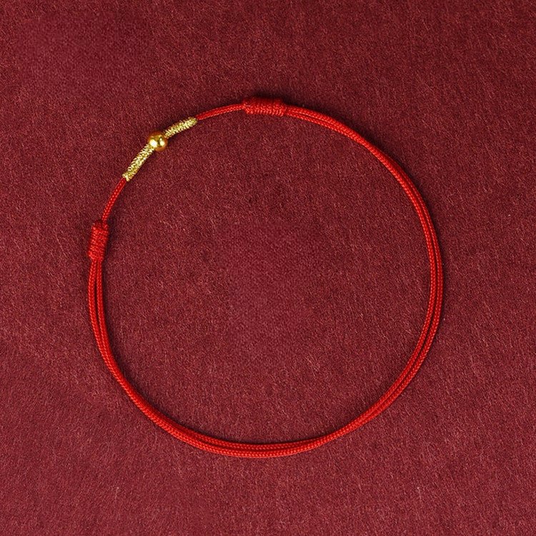 Bracelet en fil rouge nylon avec fermoir doré, style minimaliste et ajustable.