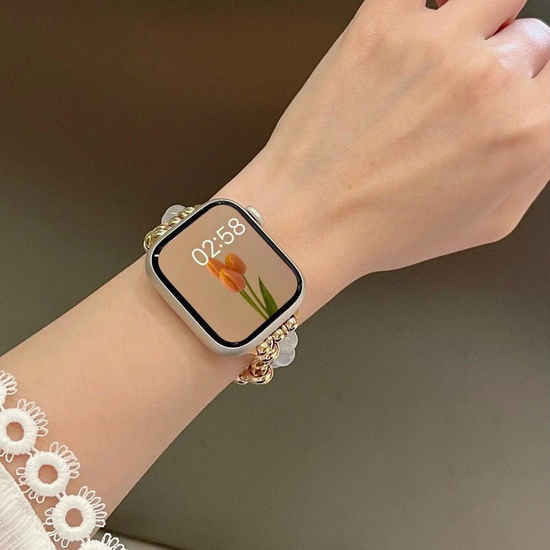 Bracelet pour Apple Watch en perles œil de chat blanches et argentées au poignet, élégant et ajustable.