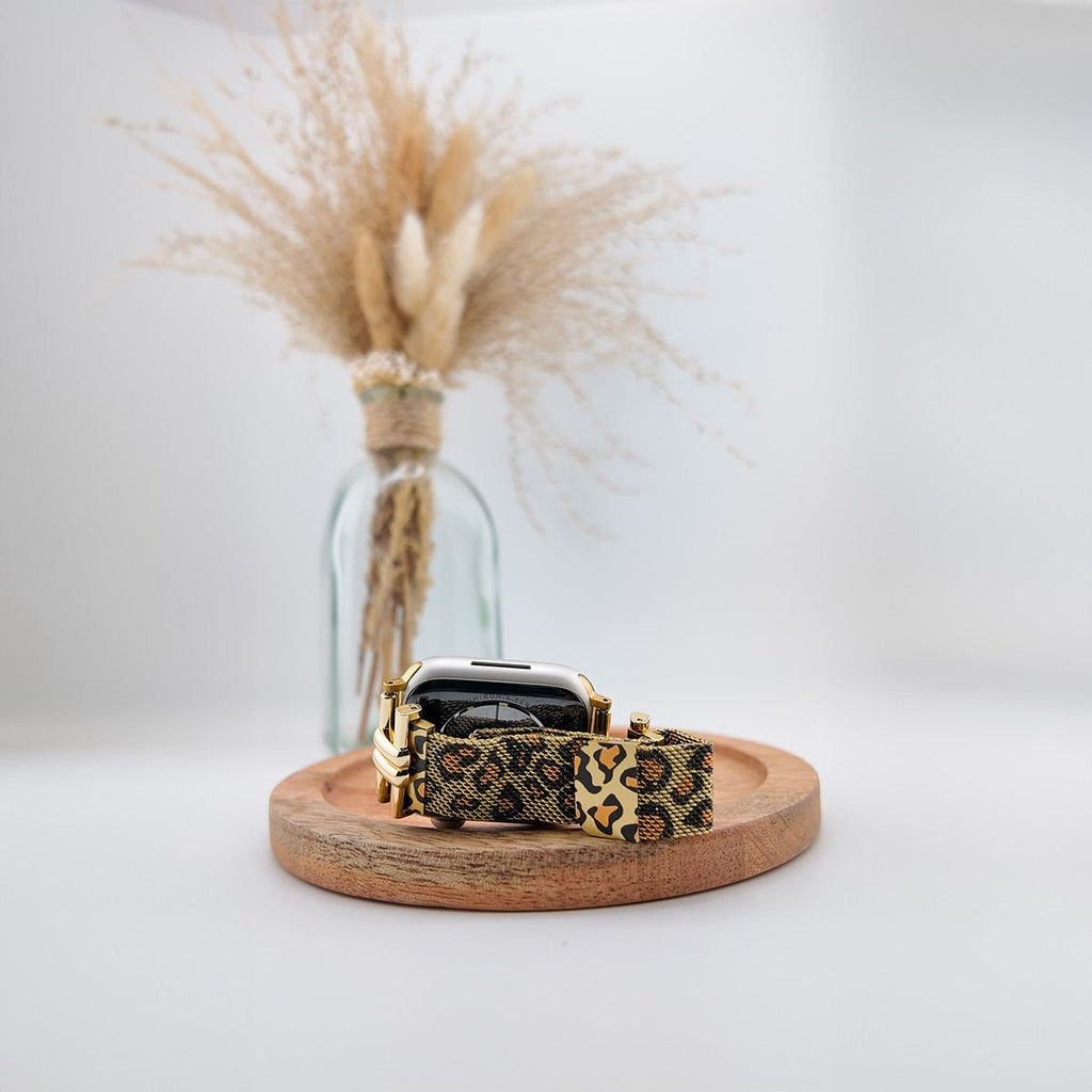Bracelet fin pour Apple Watch en cuir imprimé léopard noir et marron avec boucle dorée élégante.