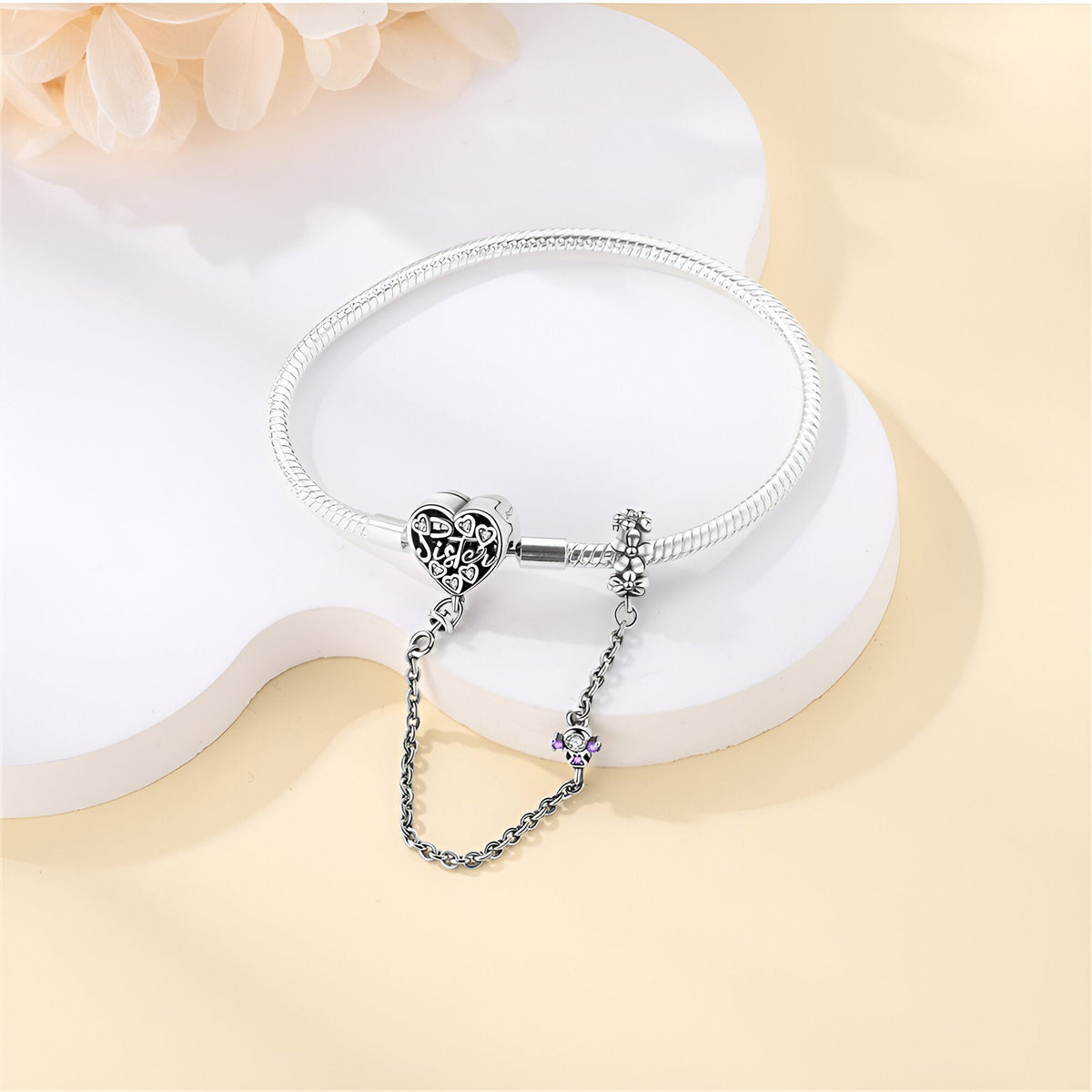 Bracelet argenté fin à chaîne avec pendentif cœur orné de détails sculptés.