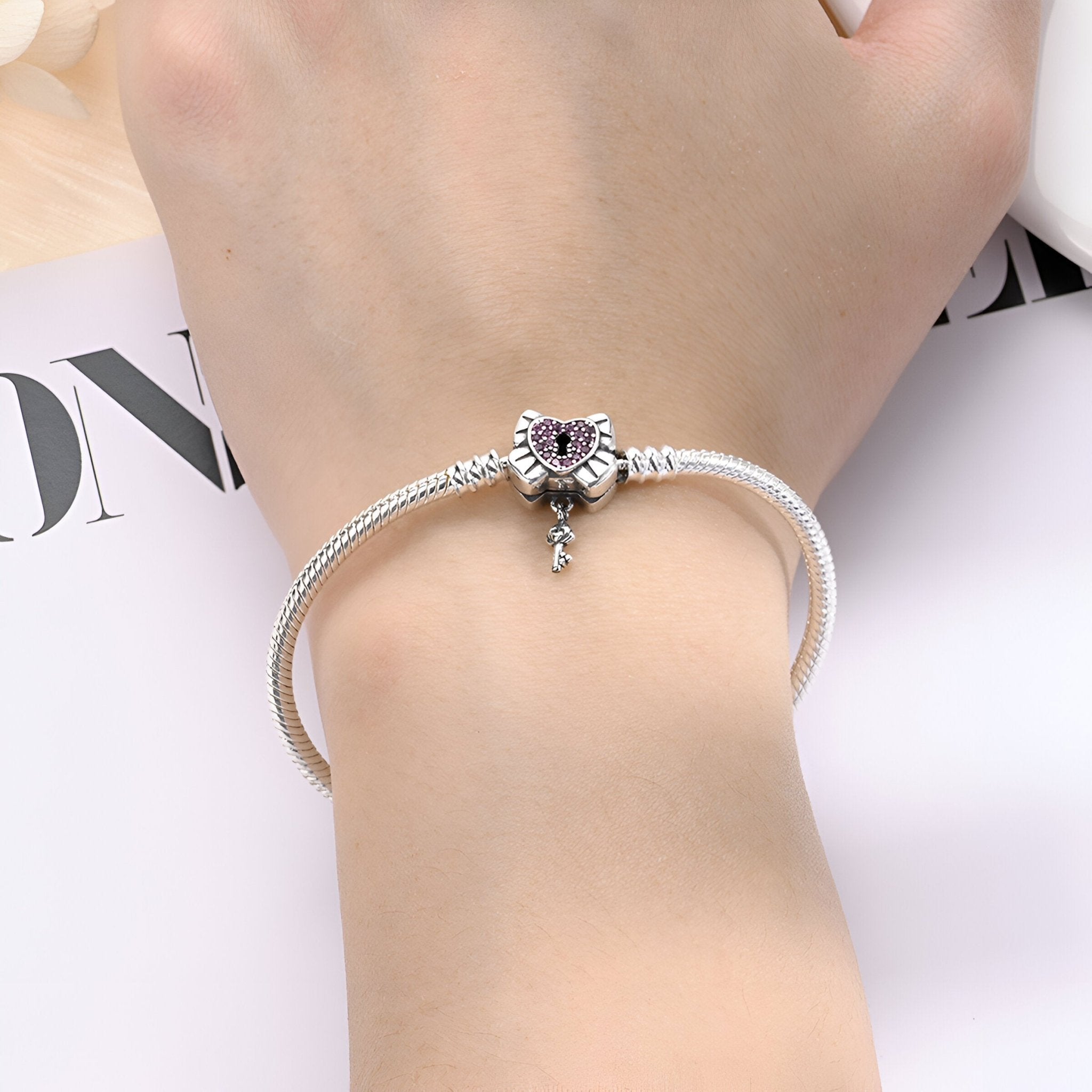 Bracelet argenté fin avec pendentif cœur cadenassé et petit charme suspendu, modèle Tanith.