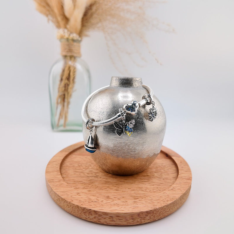 Bracelet argenté avec charms papillons et cœur bleus, style délicat pour femme, modèle Elara.