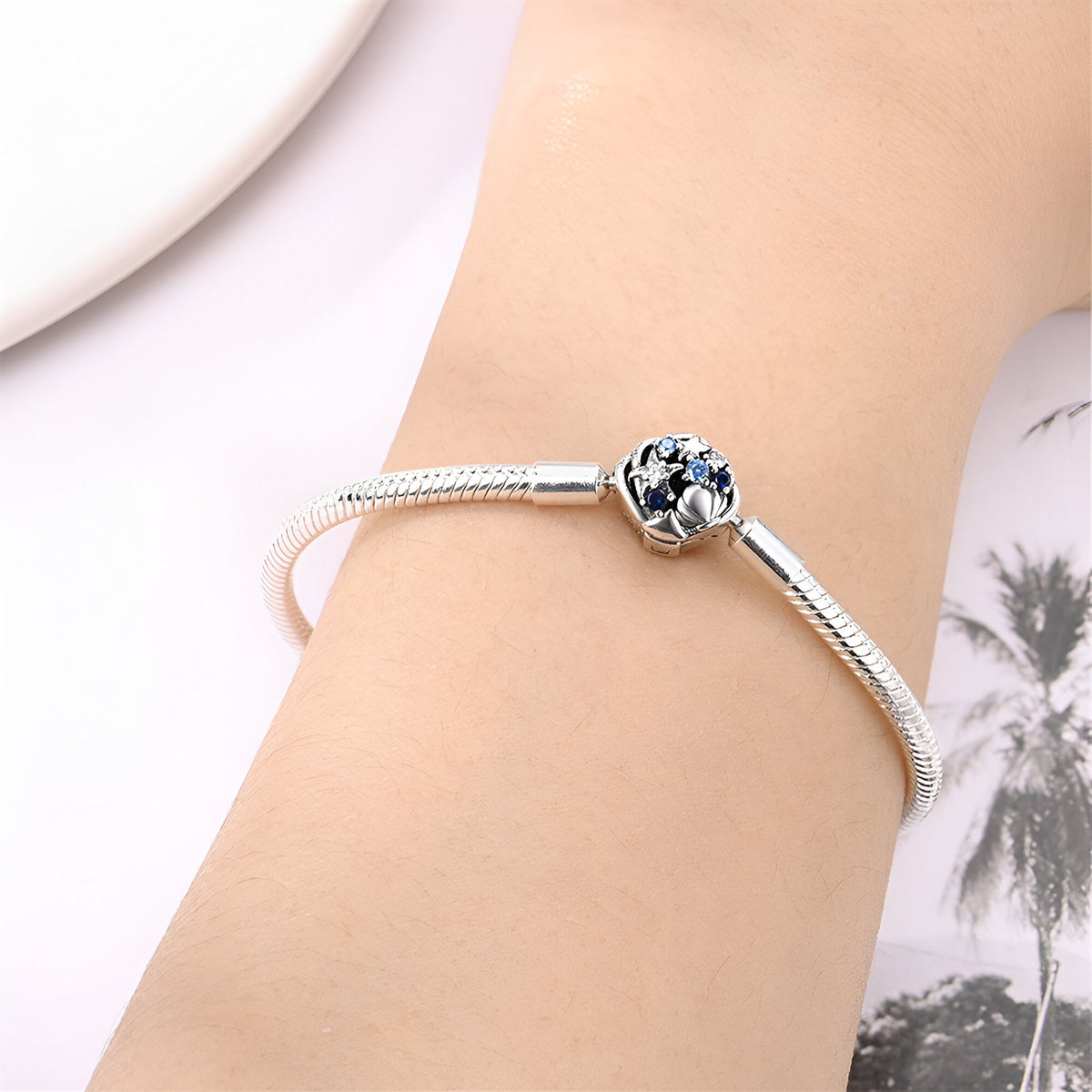 Bracelet argenté fin avec charm sphérique bleu et blanc, style élégant et minimaliste.