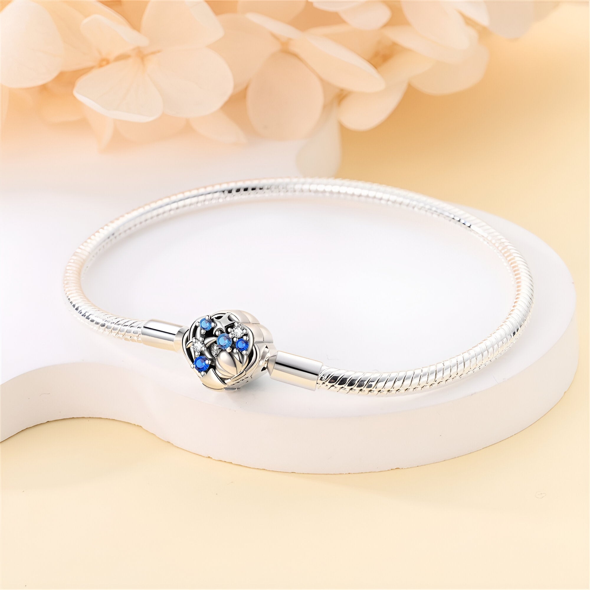 Bracelet charm en argent avec fermoir étoile orné de petites étoiles bleues et coquillage sculpté.
