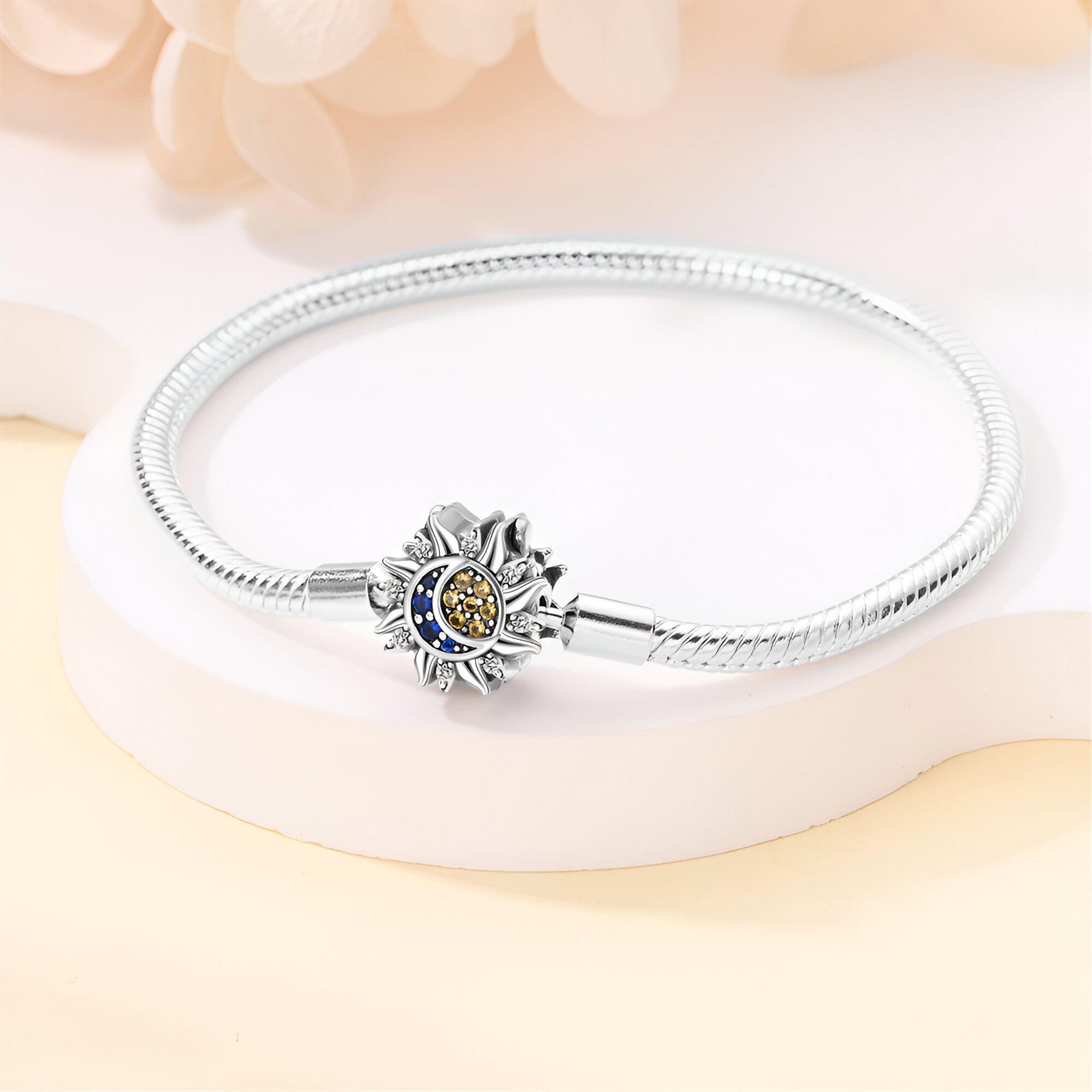 Bracelet en argent avec charm soleil et lune orné de pierres bleues, style fin et élégant.
