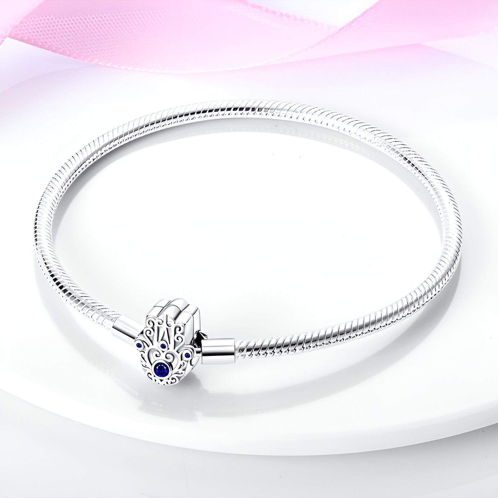 Bracelet argenté pour charms avec pendentif main de fatma orné d’un œil bleu, modèle Mireya.