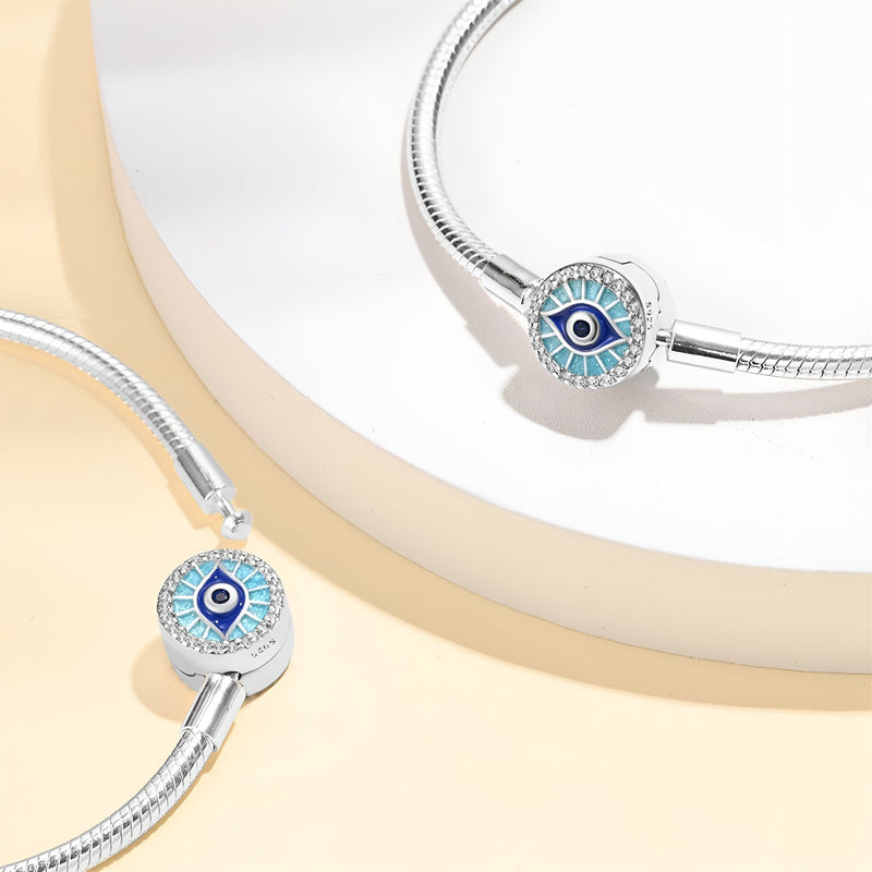 Bracelet argenté élégant avec charm œil de protection bleu sur boucle ronde texturée.