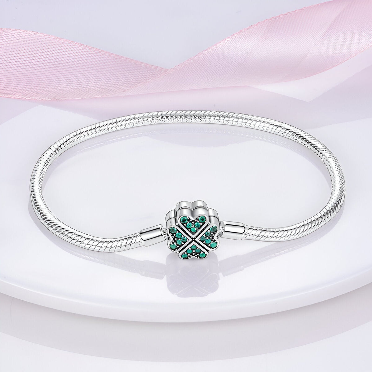 Bracelet pour charm en argent avec fermoir en forme de trèfle orné de pierres vertes.