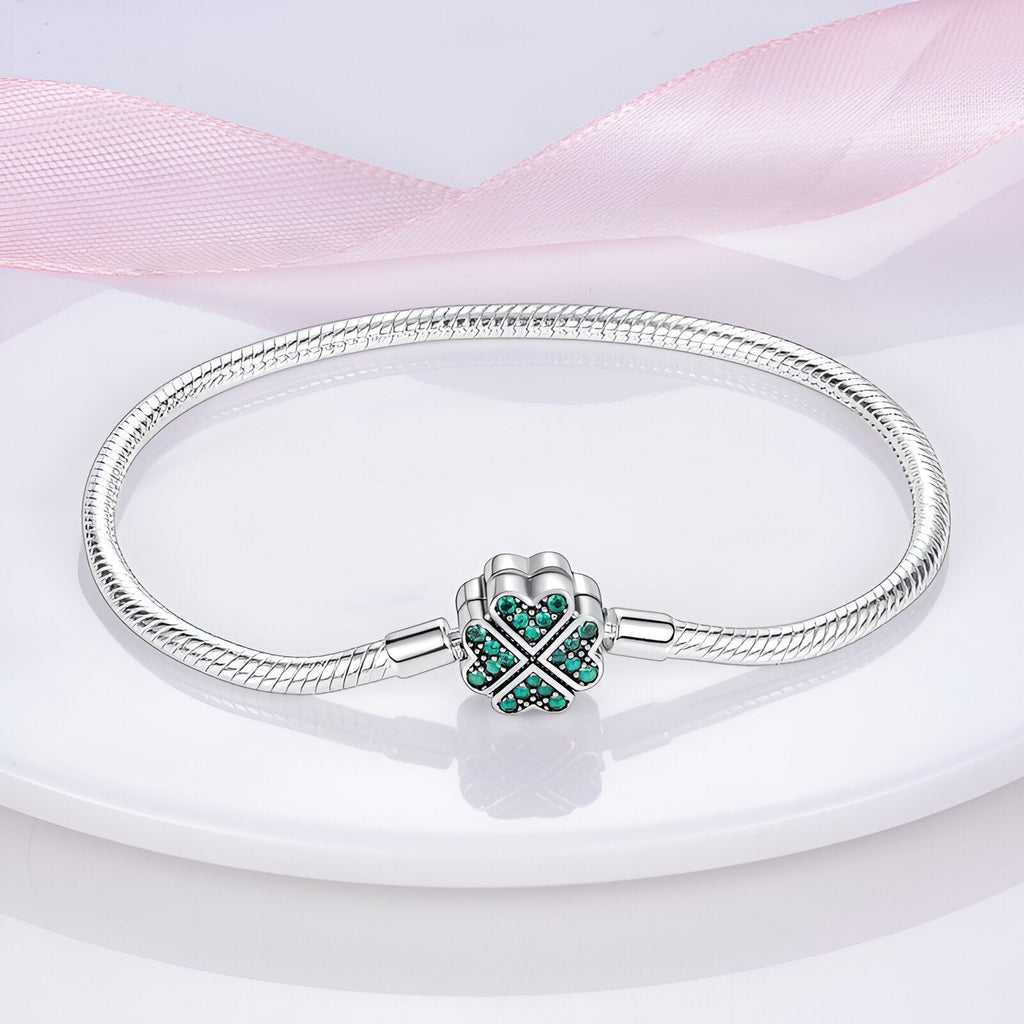 Bracelet pour charm en argent avec fermoir en forme de trèfle orné de pierres vertes.