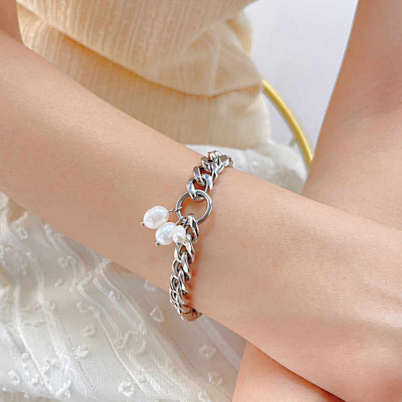 Bracelet pour femme en acier inoxydable argenté avec perles pendantes raffinées.