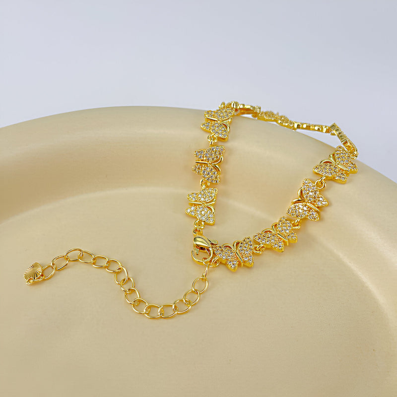 Bracelet femme en cuivre doré avec papillons sertis de zirconiums scintillants.