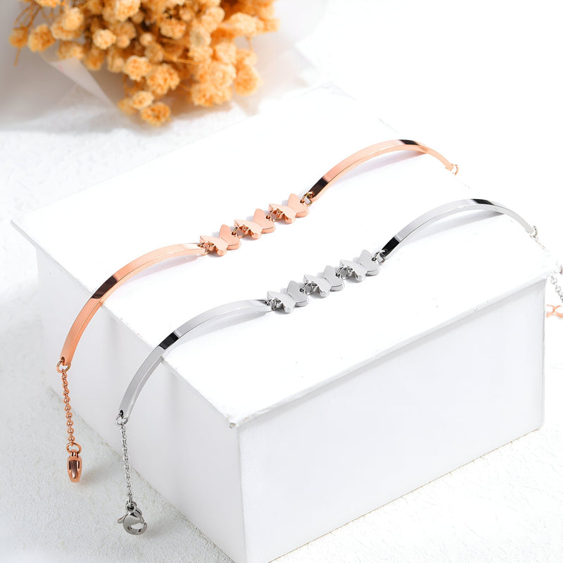 Bracelet femme en acier inoxydable or rosé avec papillons volants délicats et fermeture ajustable, assorti d’un modèle.
