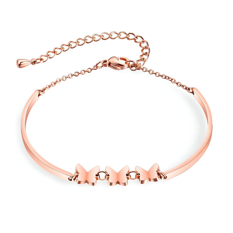 Bracelet femme en acier inoxydable or rosé avec trois papillons en relief et chaîne réglable.