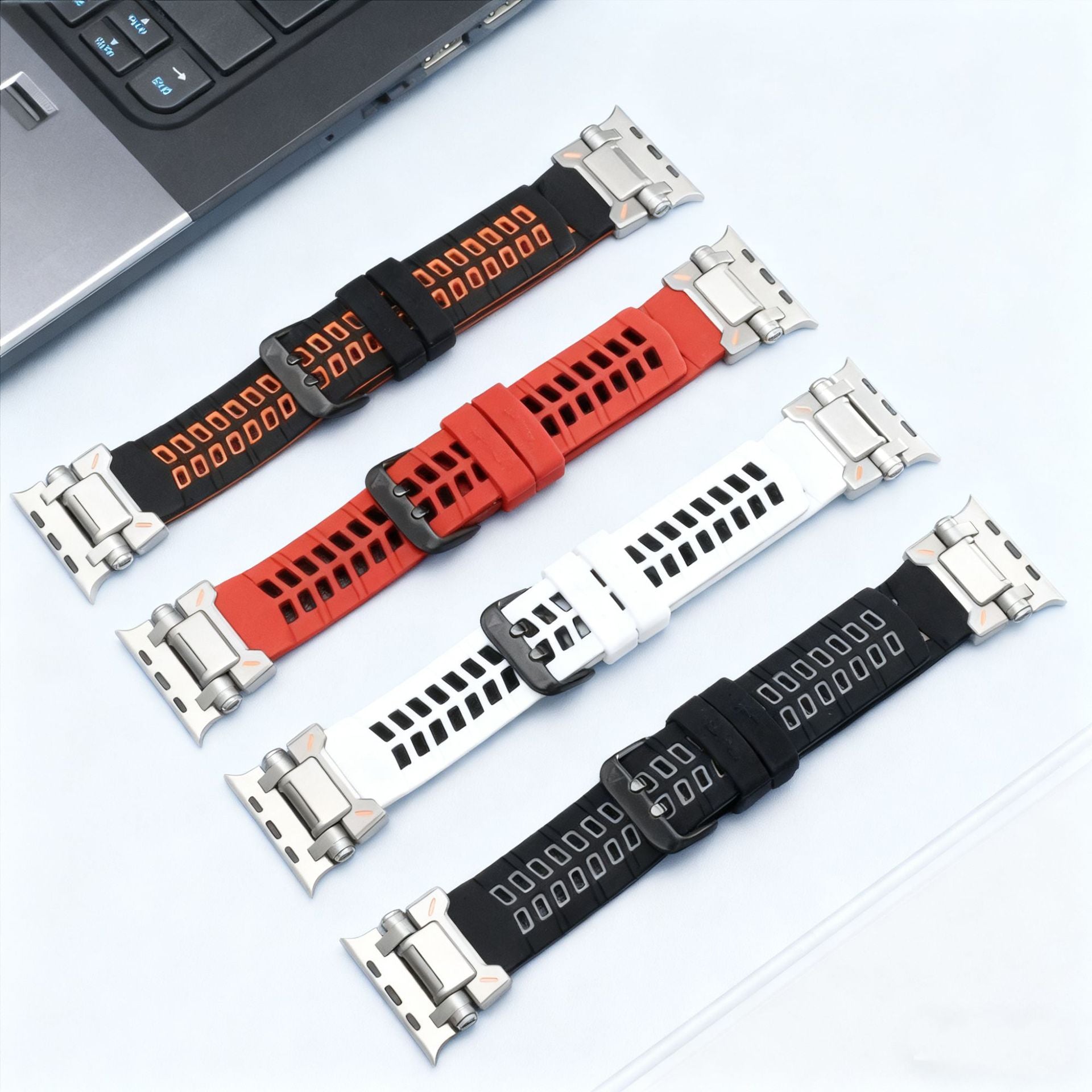 Bracelets silicone perforés pour Apple Watch en noir, blanc, rouge, et noir avec logo orange, fermeture ardillon métallique,