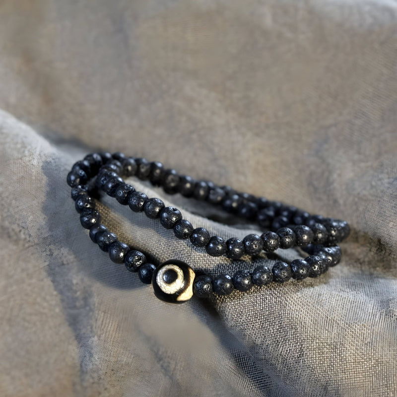 Bracelet noir en pierres volcaniques lisses avec perle centrale Dzi beige noire, style tibétain, mixte.