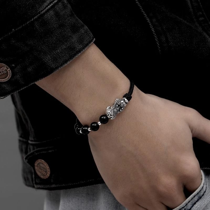 Bracelet tibétain en obsidienne noire avec perles argentées et pendentif Pi Xiu détaillé.