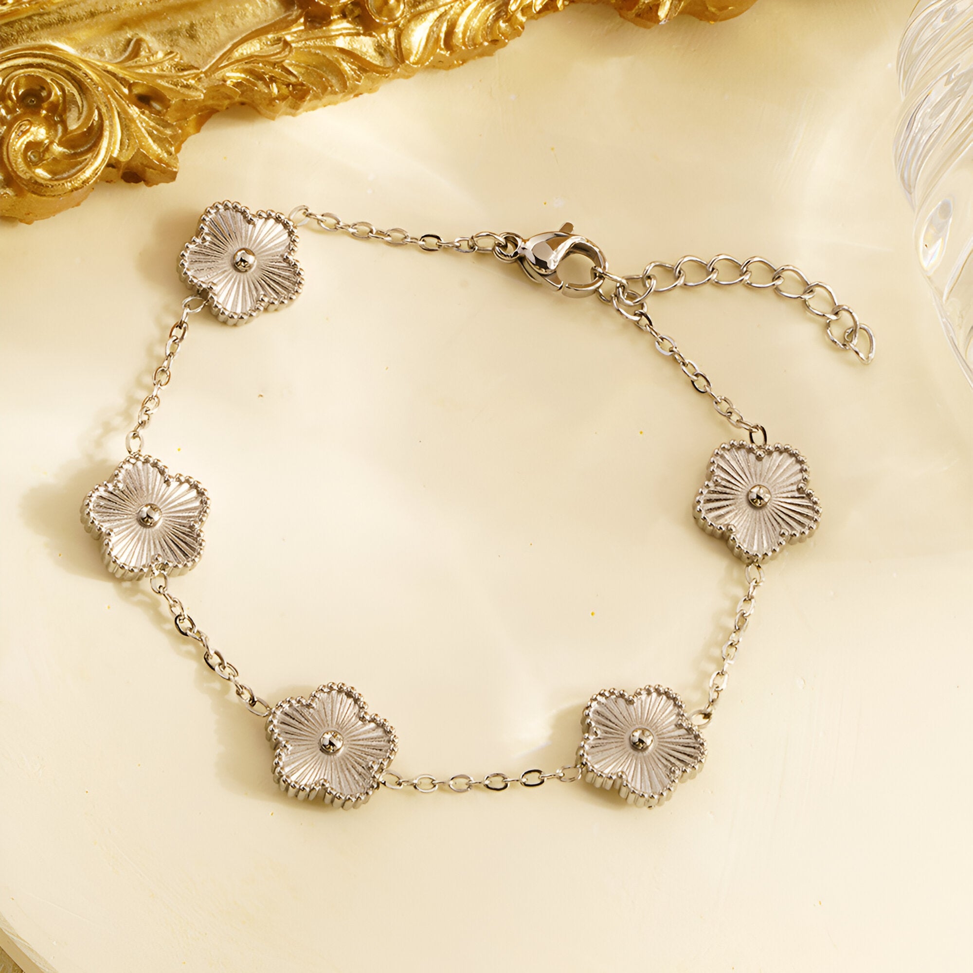 Bracelet en acier inoxydable argenté avec cinq pendentifs fleurs détaillés et chaîne ajustable.