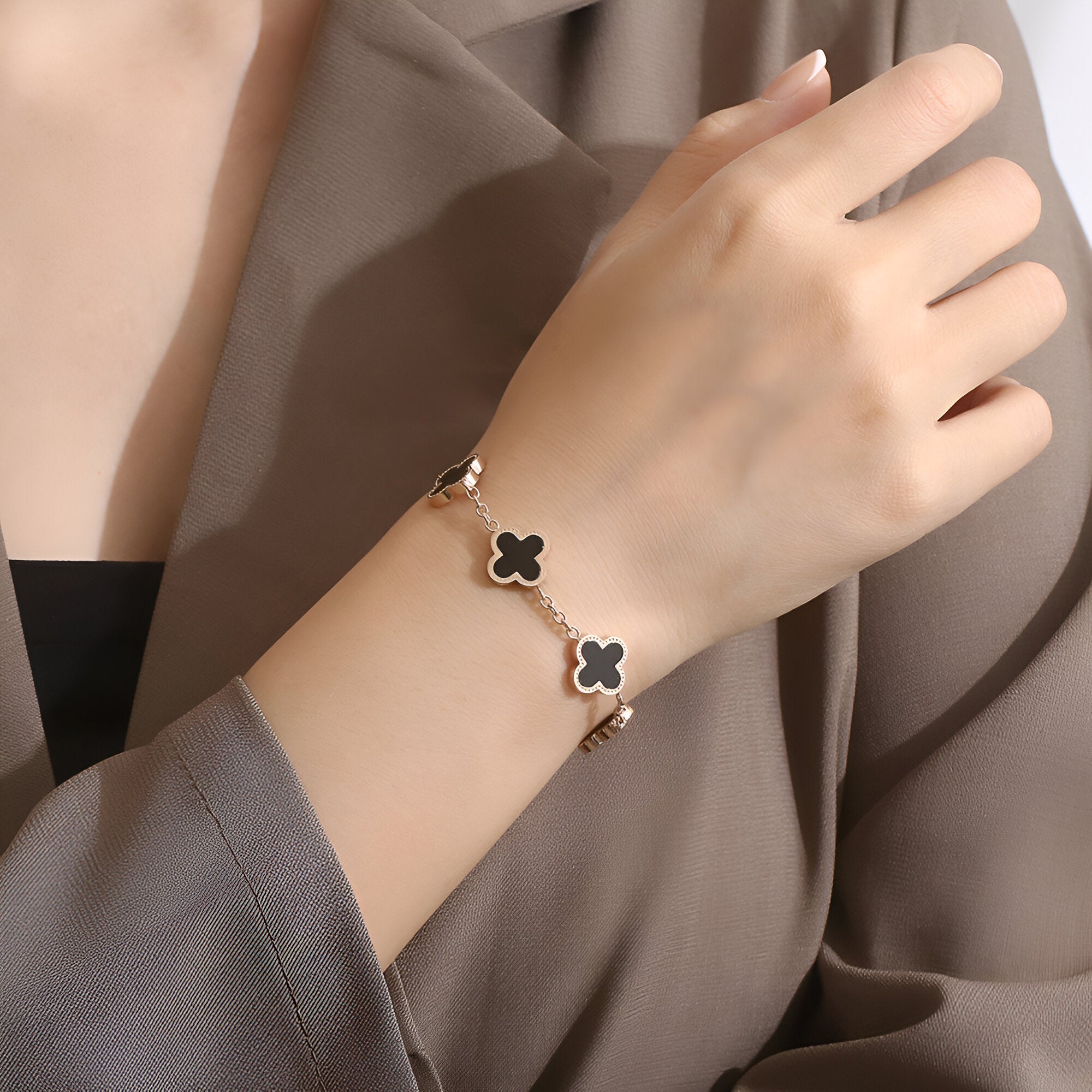 Bracelet femme en titane noir avec motifs trèfles magnétiques dorés, élégant et moderne.
