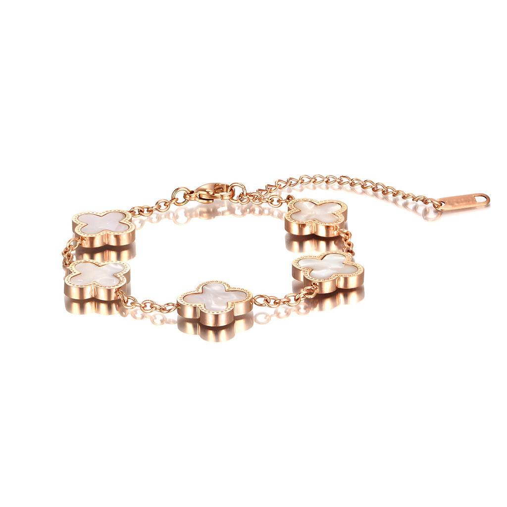 Bracelet femme en titane doré avec quatre pendentifs trèfle en nacre blanche sur chaîne fine.