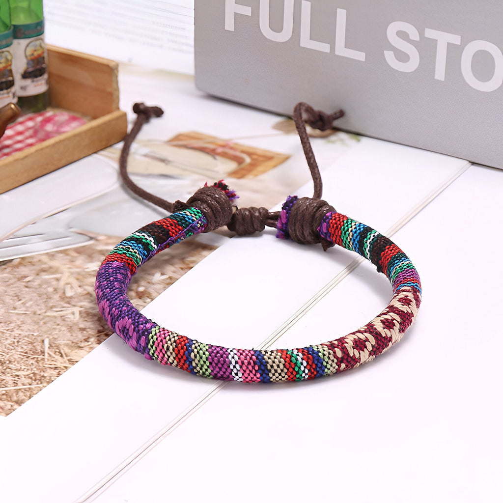 Bracelet tressé en coton multicolore à motifs géométriques avec fermeture coulissante en corde marron.