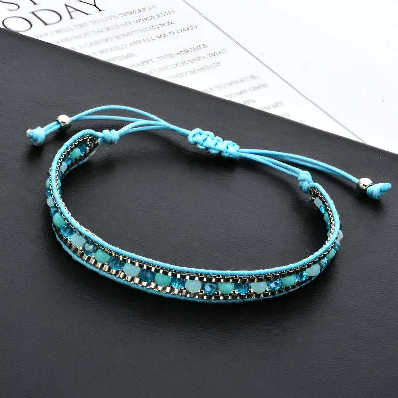 Bracelet tressé turquoise avec perles de riz noires et argentées, fermoir coulissant réglable.