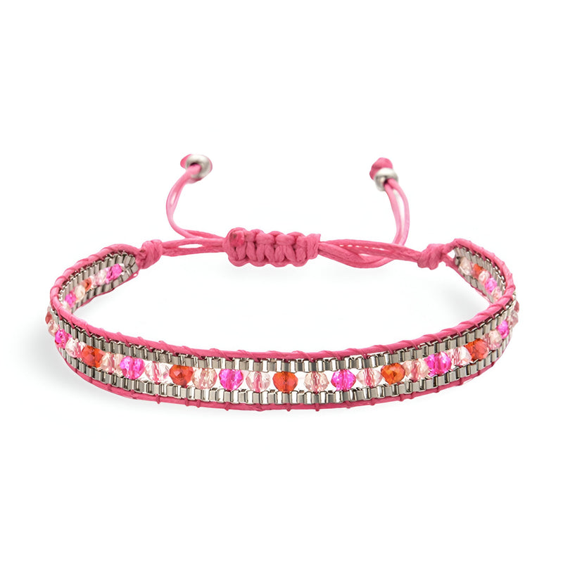 Bracelet tressé rose avec perles blanches et rouges, fermeture ajustable à nœud coulissant.