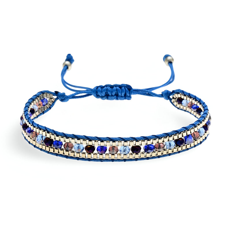 Bracelet tressé bleu avec perles de riz argentées et perles bleues foncées, fermeture ajustable nouée.