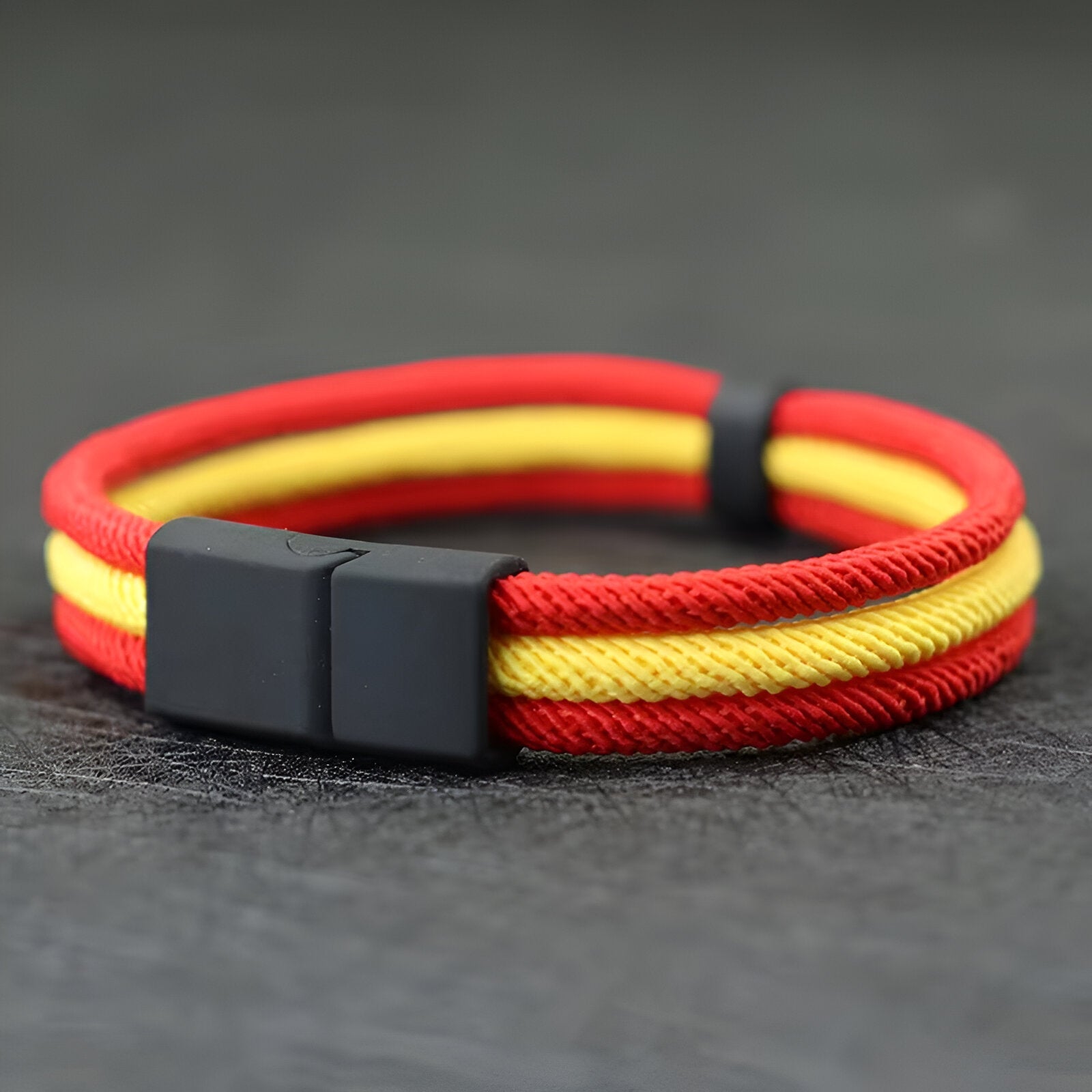 Bracelet triple cordons rouge et jaune avec fermoir noir mat, style masculin et épuré.