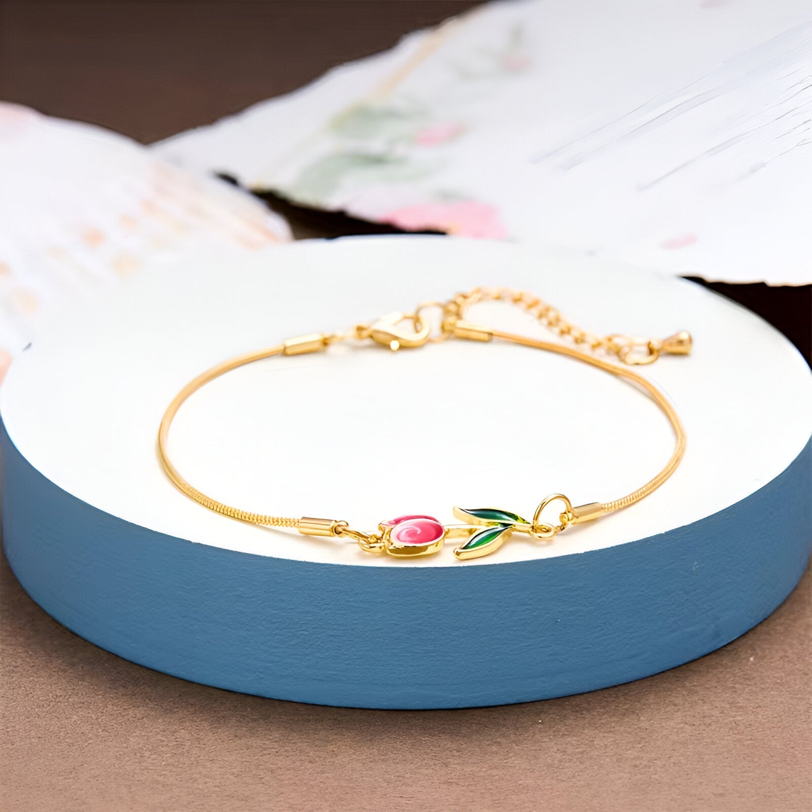 Bracelet en cuivre doré avec pendentif tulipe rose et feuilles vertes, chaîne fine réglable.