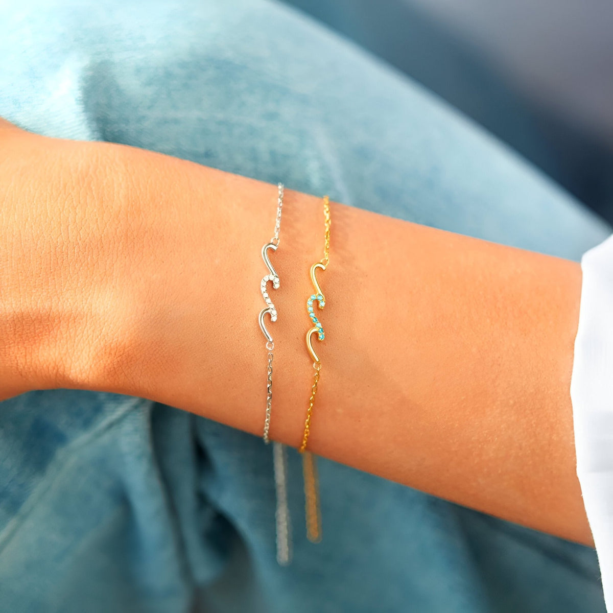 Bracelet fin en argent sterling avec motif vagues scintillantes porté au poignet, déclinaisons or et argent.