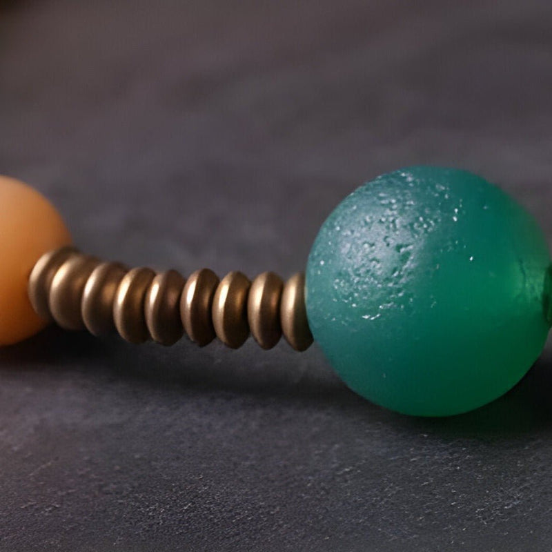 Bracelet vert en graines de Bodhi et perles agate orange avec anneaux métalliques dorés.