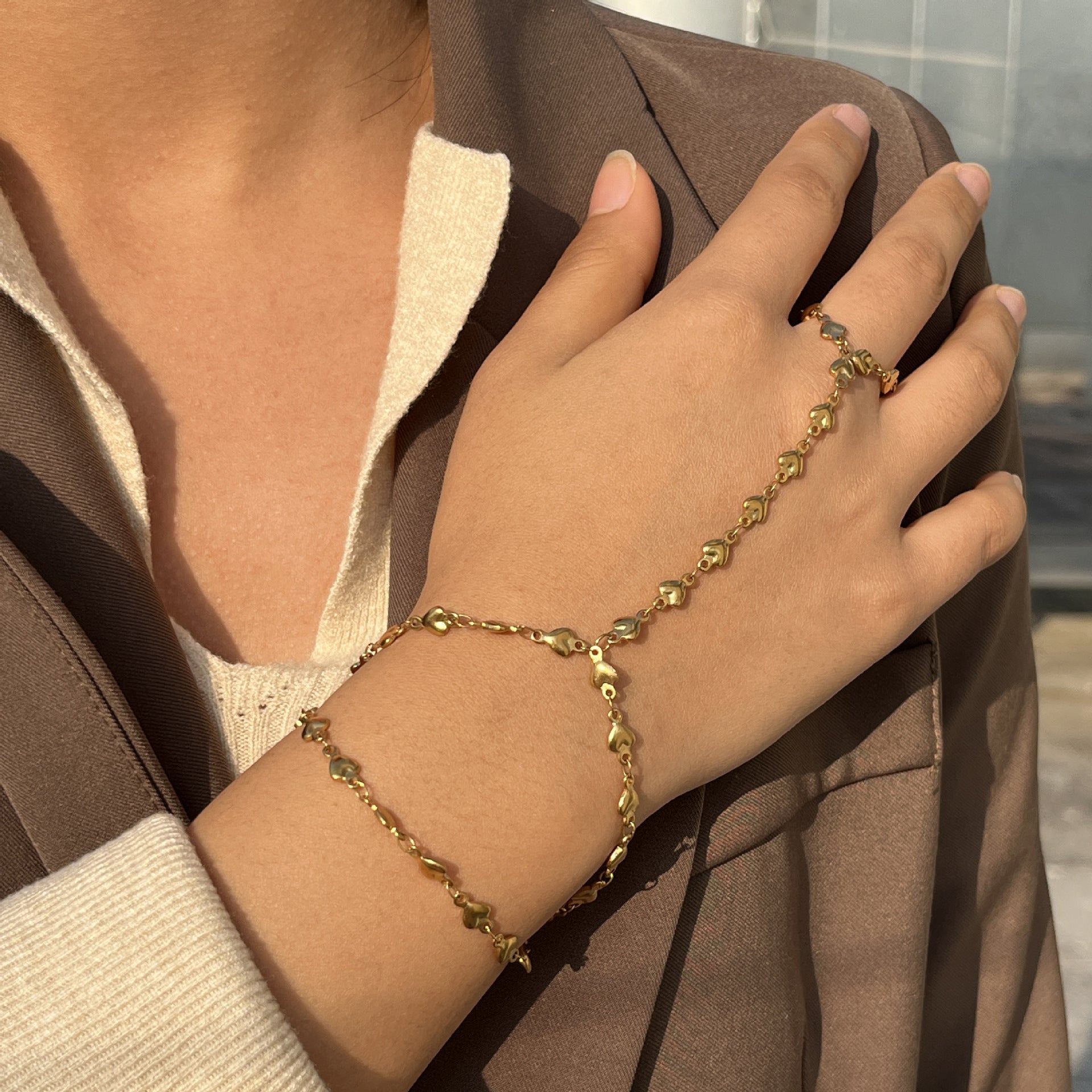 Bijou de main doré en acier inoxydable avec cœurs, bracelet chaîne reliant doigt et poignet pour femme.