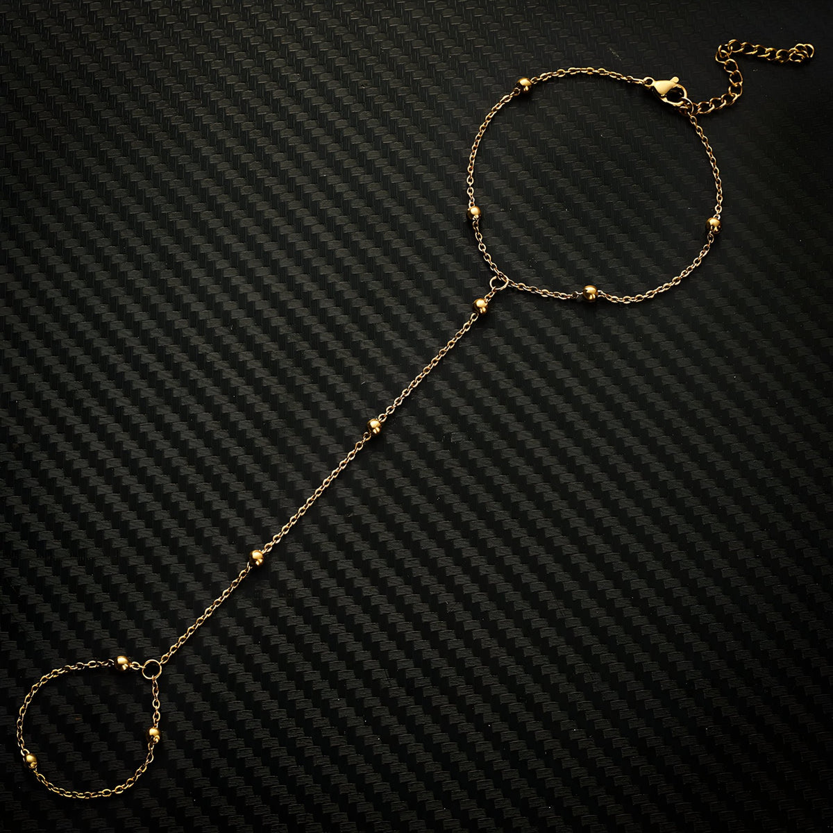 Bracelet de main en acier inoxydable doré avec perles fines et chaîne élégante.