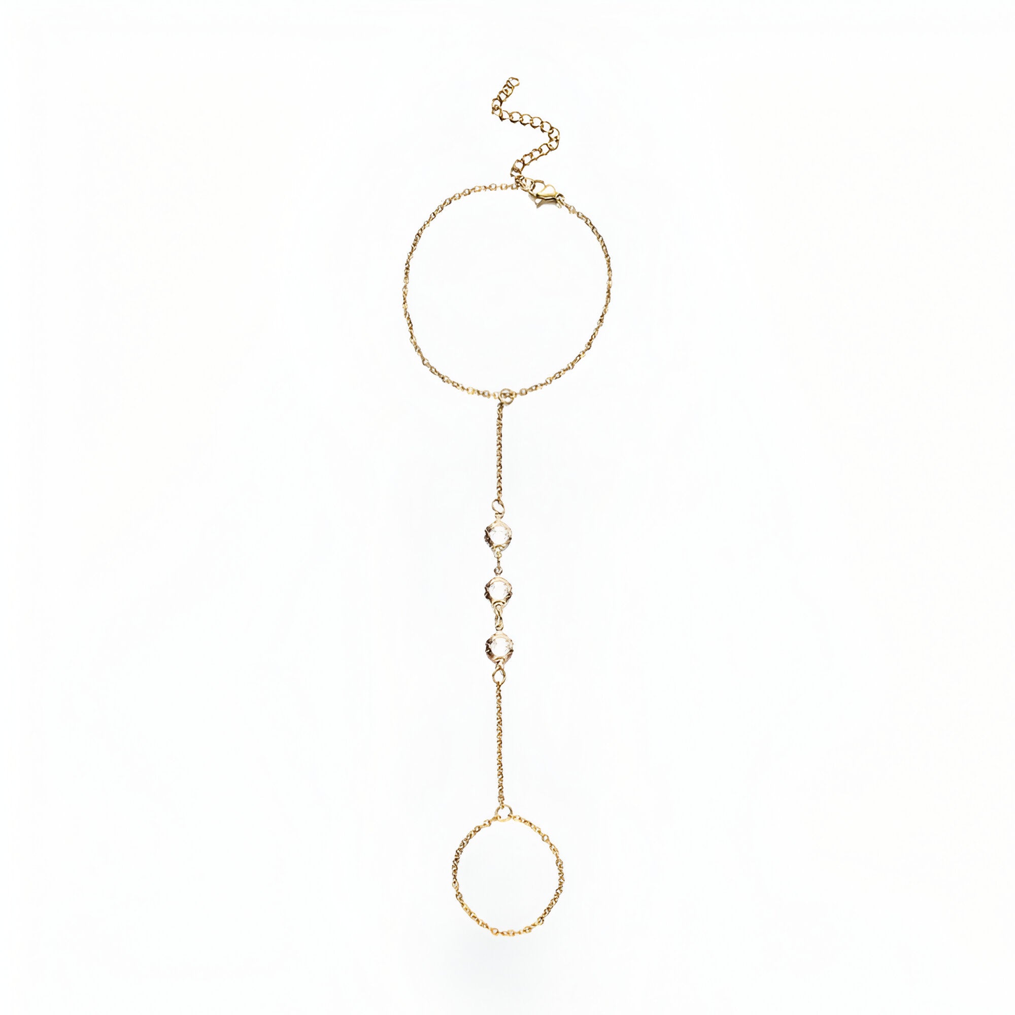 Bijou de main en acier inoxydable doré avec chaîne fine et anneaux ronds décorés de petits zirconiums blancs.