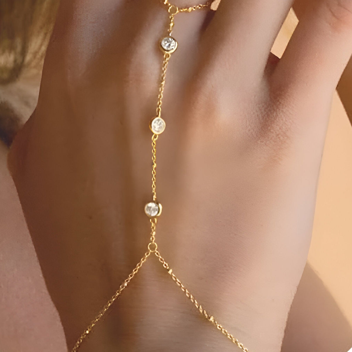 Bijou de main doré en acier inoxydable avec zirconiums ronds, style chaîne délicate pour femme.