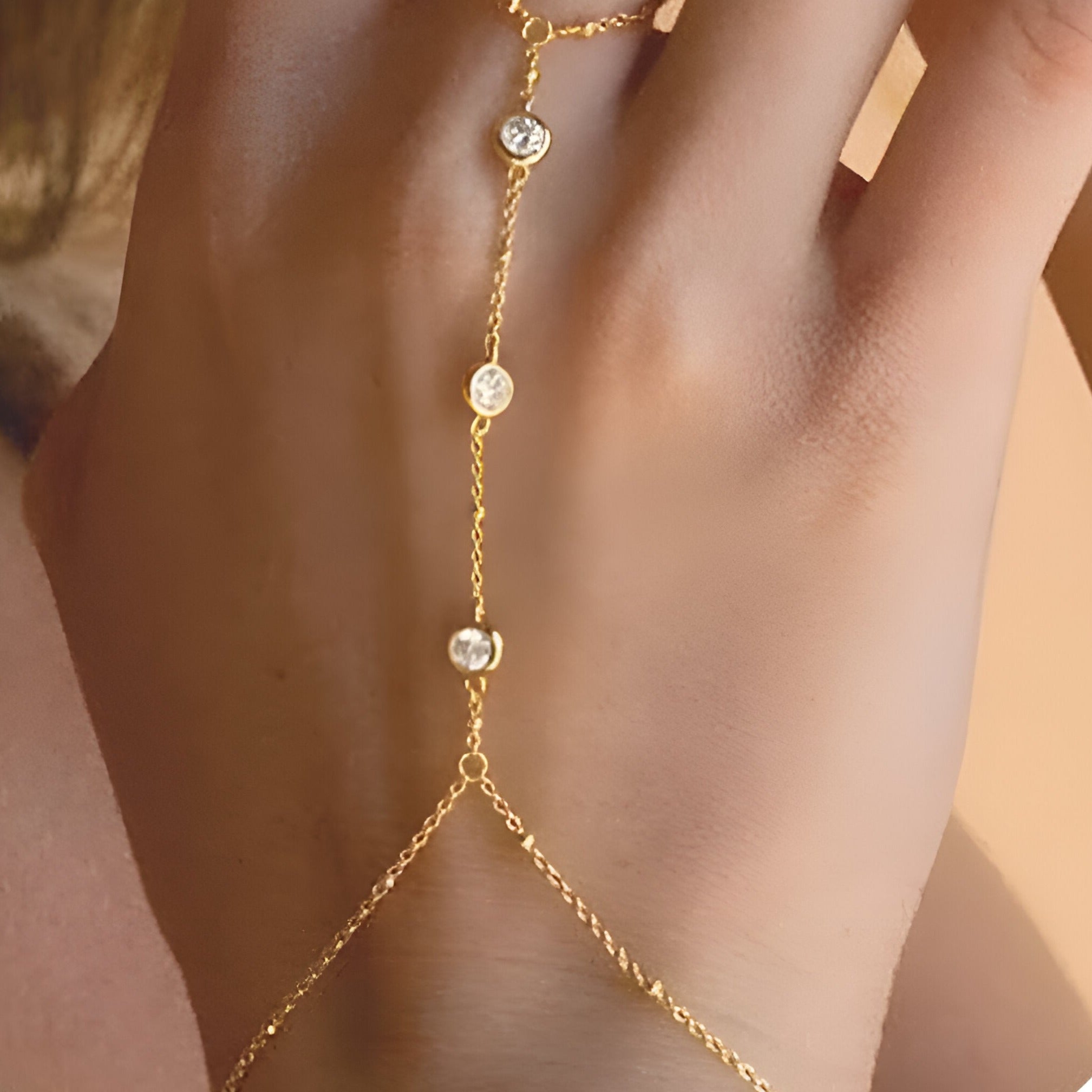 Bijou de main doré en acier inoxydable avec zirconiums ronds, style chaîne délicate pour femme.