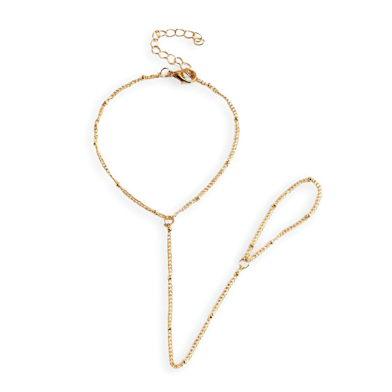Bijou de main en acier inoxydable doré, bracelet chaîne fine reliant poignet et doigt, style minimaliste.