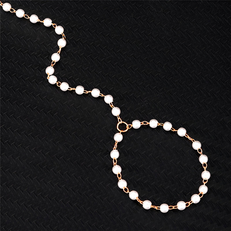 Bijou de main en acier inoxydable or avec perles blanches, chaîne fine et élégante.