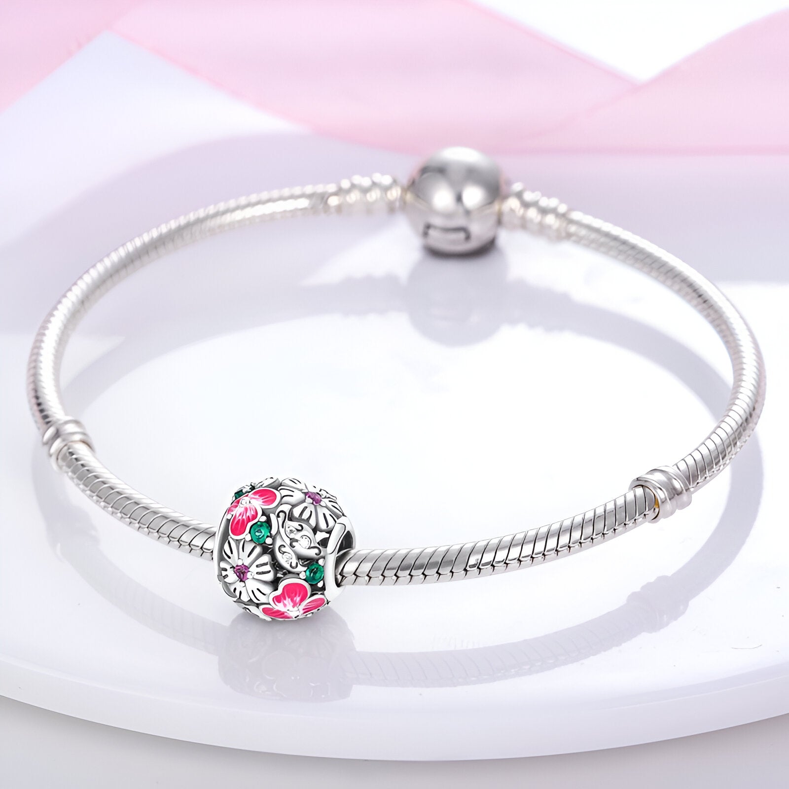 Bracelet argent avec charm floral Athalie orné de fleurs roses et blanches détaillées.