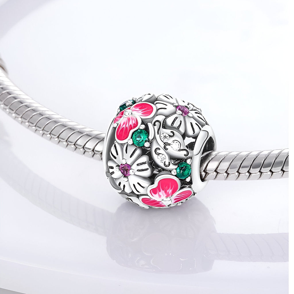 Charm rond en argent avec fleurs roses et blanches émaillées, détail feuillage vert, modèle Athalie.